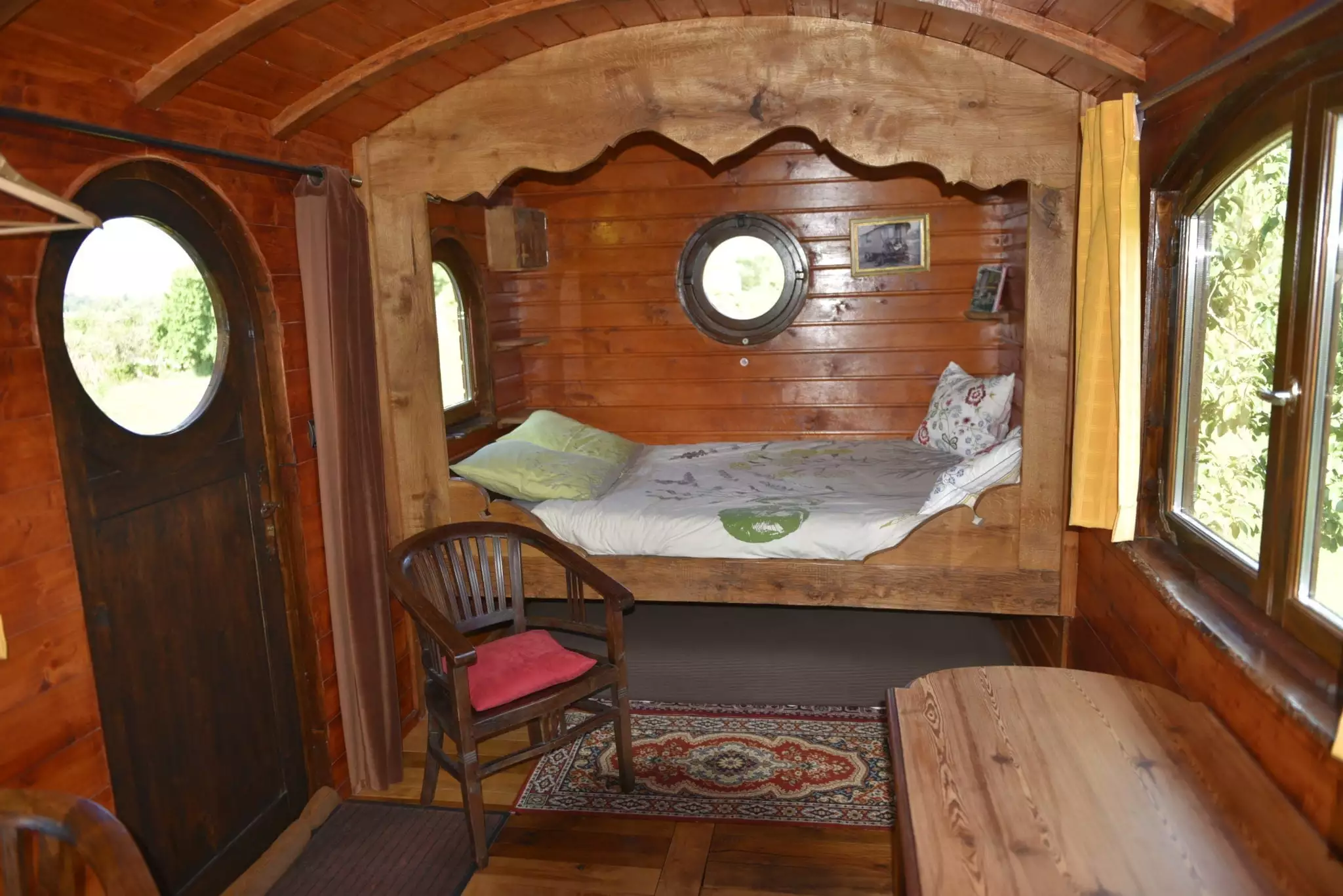 La chambre: un grand lit et un futon pour un enfant roulotte en bretagne: le lit en alcôve