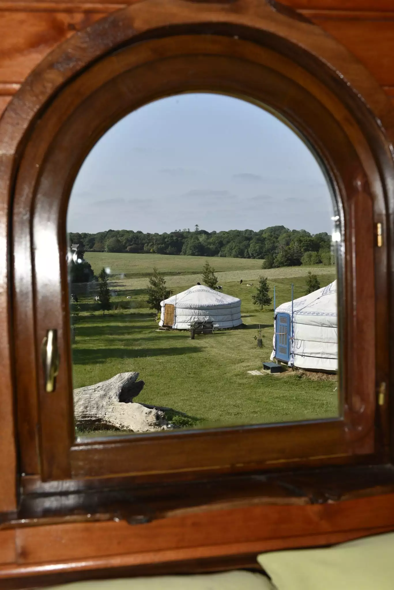 Les yourtes au travers de la fenêtre de la roulotte roulotte en bretagne: vue de la chambre